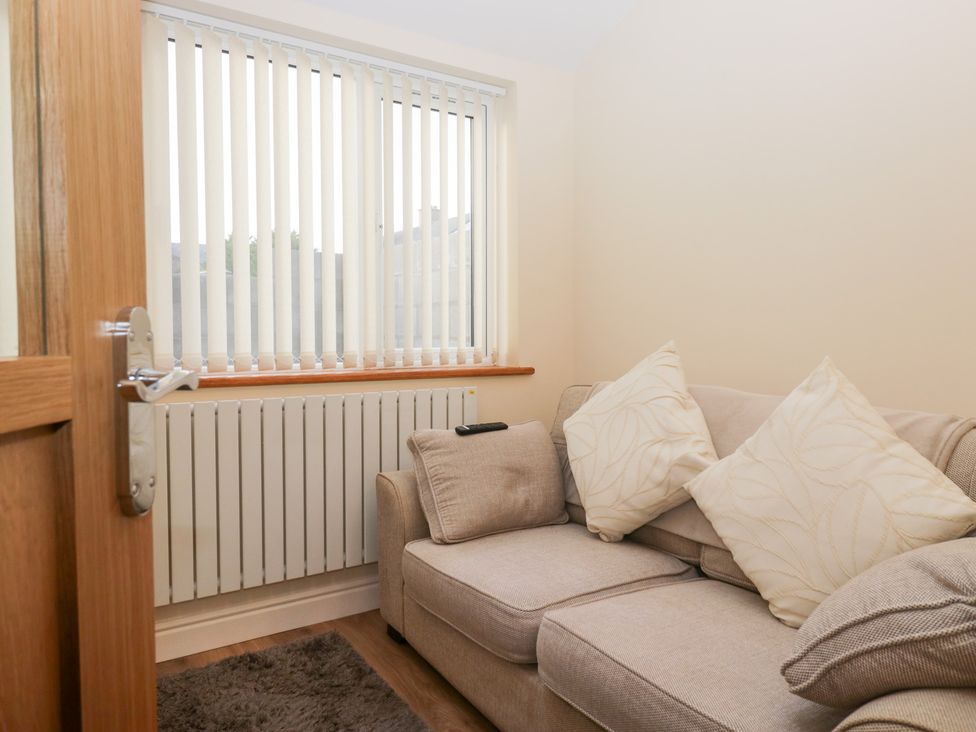 A small sitting room with a sofa and window blinds at Mables in Wigton