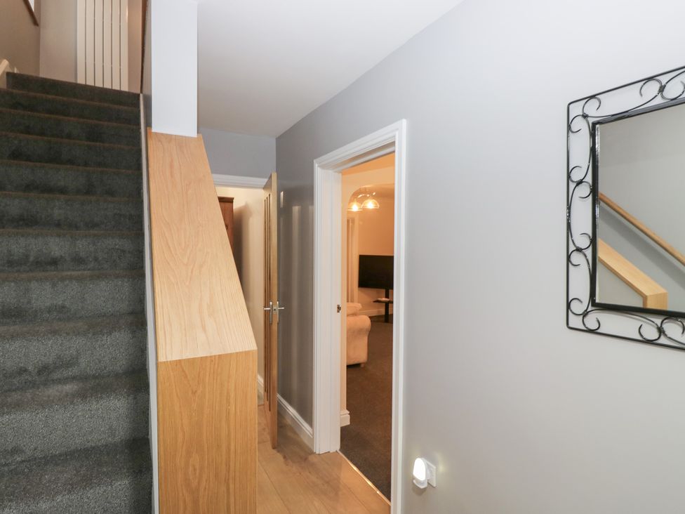 A hallway with staircase and mirror at Mables in Wigton