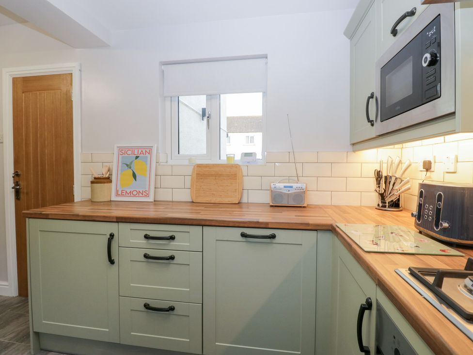 A kitchen with a microwave and cutting board at Mables in Wigton