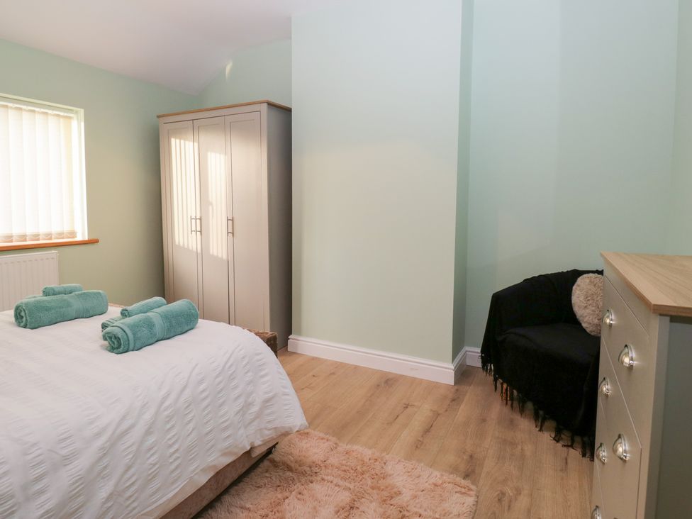 A bedroom with a bed and towels at Mables in Wigton