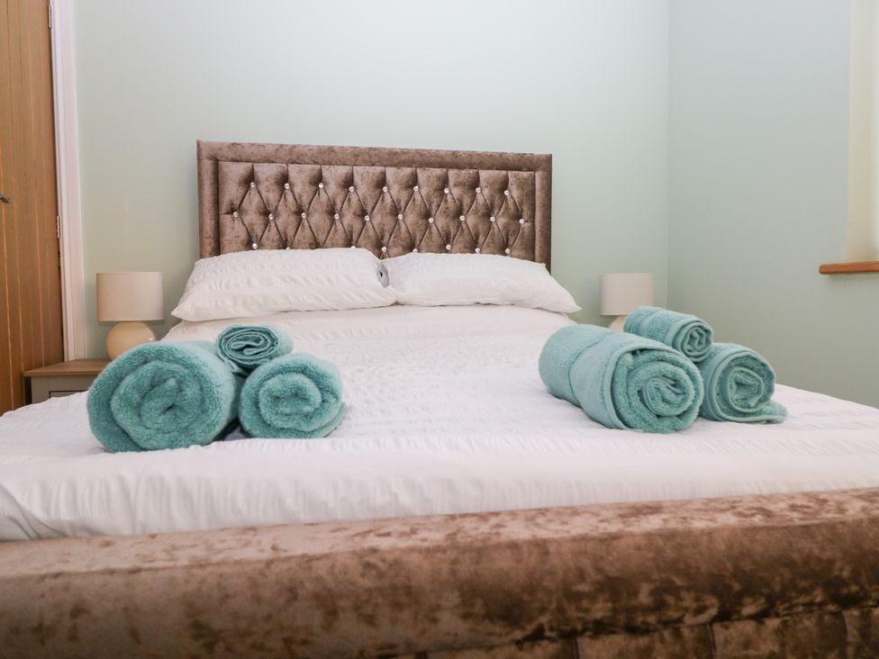 A bedroom with a bed and towels on it at Mables in Wigton