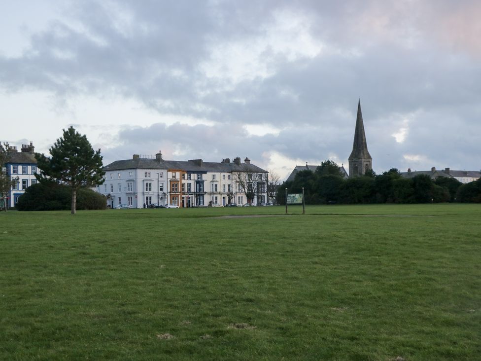 A park with buildings and a church in the background at Mables in Wigton