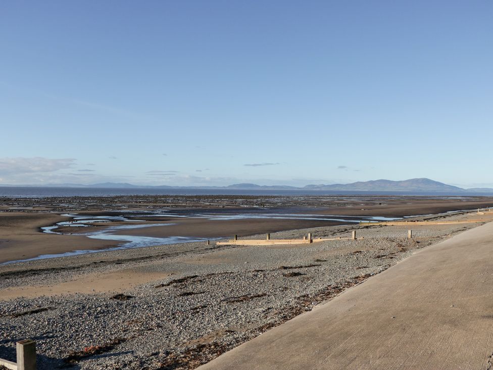 A beach with a river flowing and mountains in the background at Mables in Wigton