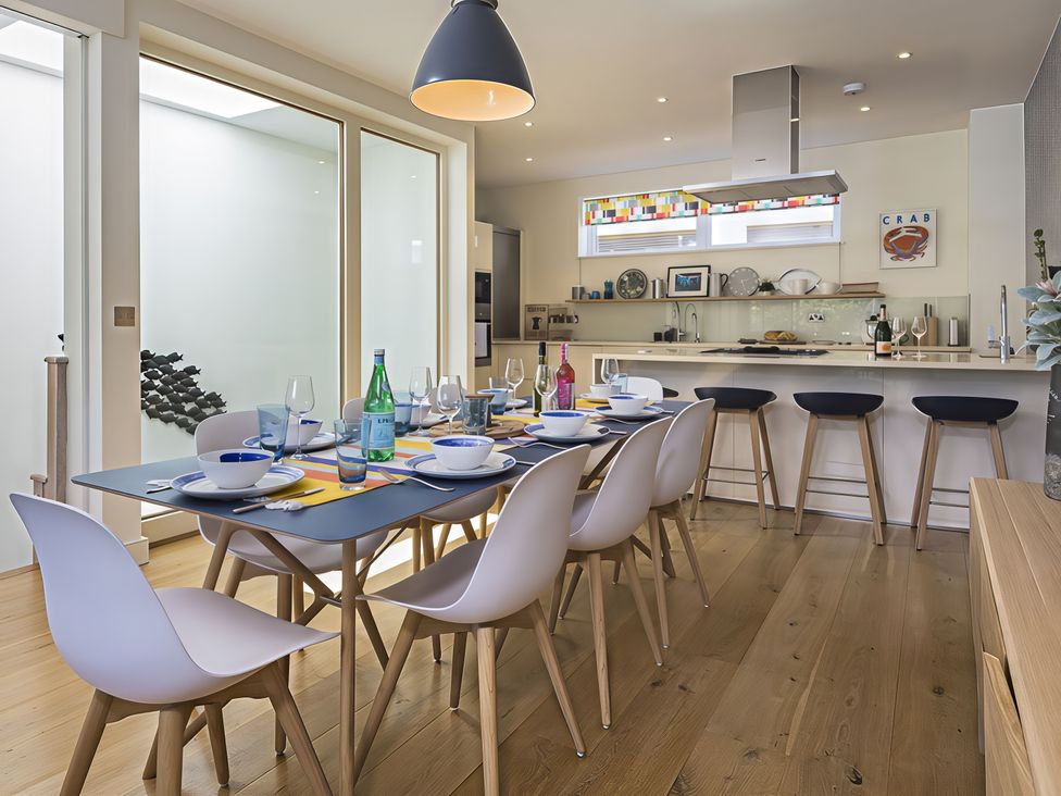 A dining room with a table set for a meal at Villa 8, Estura in Salcombe