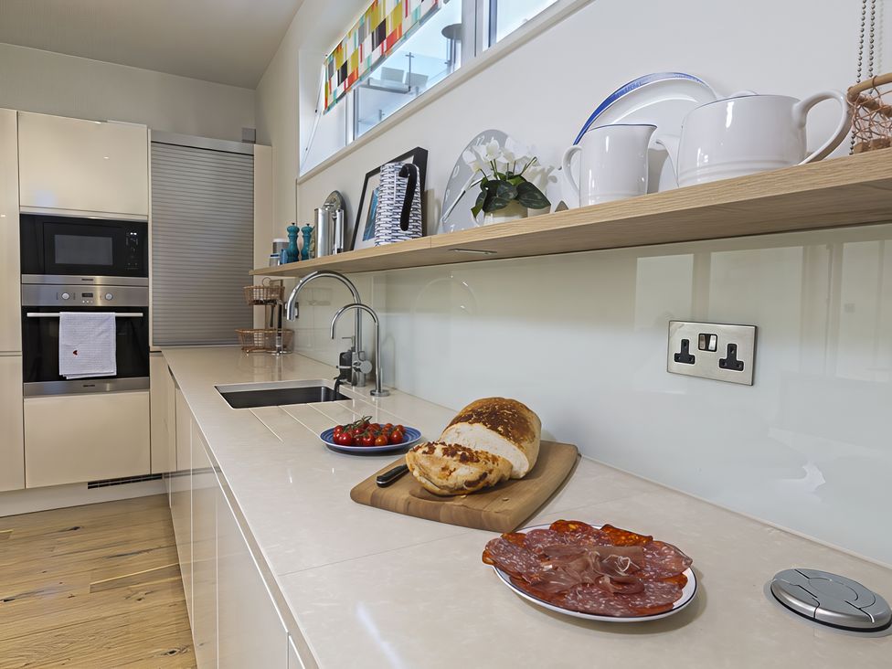 A kitchen with a sink, oven, and various food items at Villa 8, Estura in Salcombe