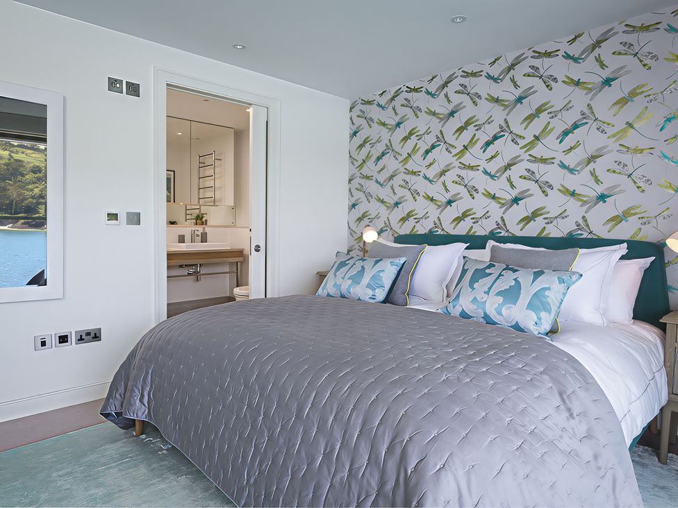 A bedroom with a bed and an adjoining bathroom at Villa 8, Estura in Salcombe