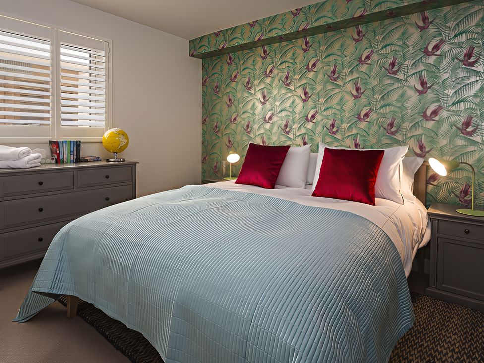 A bedroom with a bed and a dresser at Villa 8, Estura Salcombe