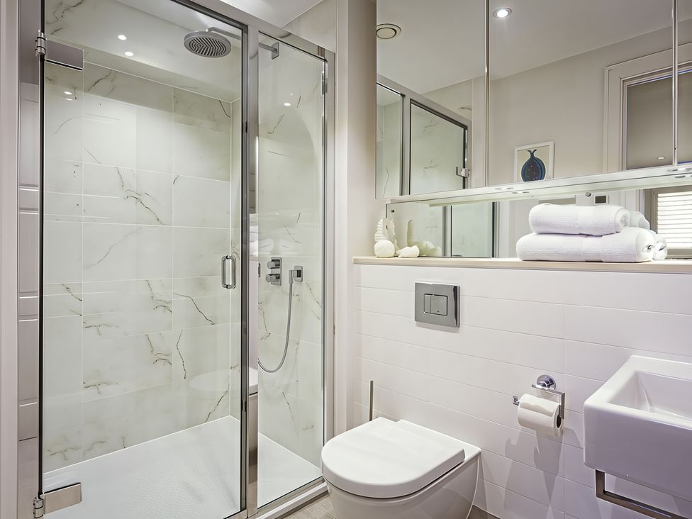 A bathroom featuring a shower, toilet, and wash basin at Villa 8, Estura Salcombe