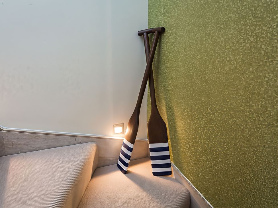 A staircase with wooden paddles mounted on the wall at Villa 8, Estura Salcombe