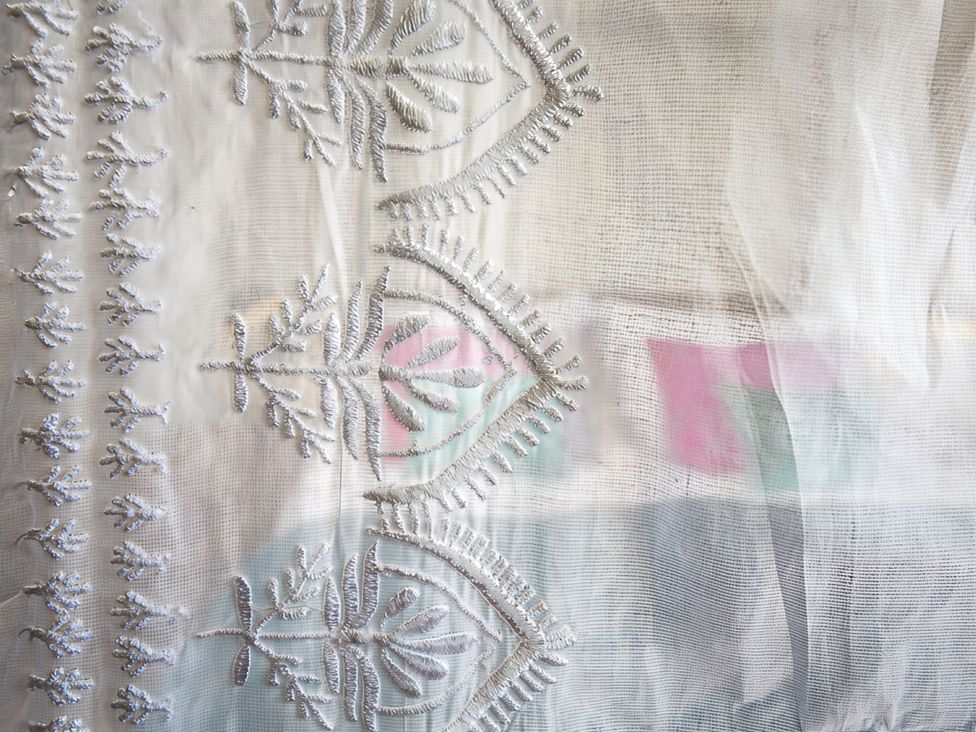 A close-up of embroidered fabric with intricate designs