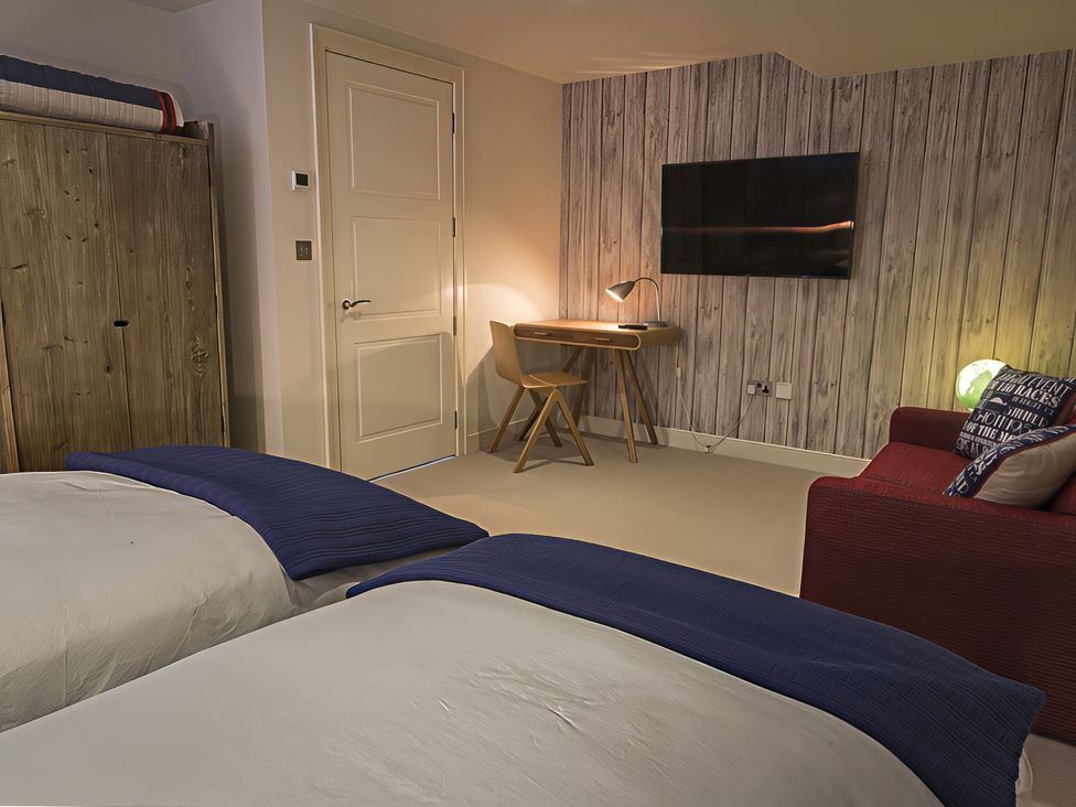 A bedroom with two beds and a desk at Villa 8, Estura Salcombe