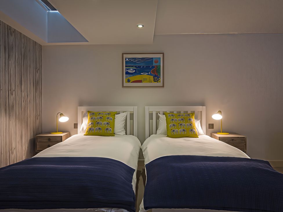 A bedroom with two beds and artwork at Villa 8, Estura, Salcombe