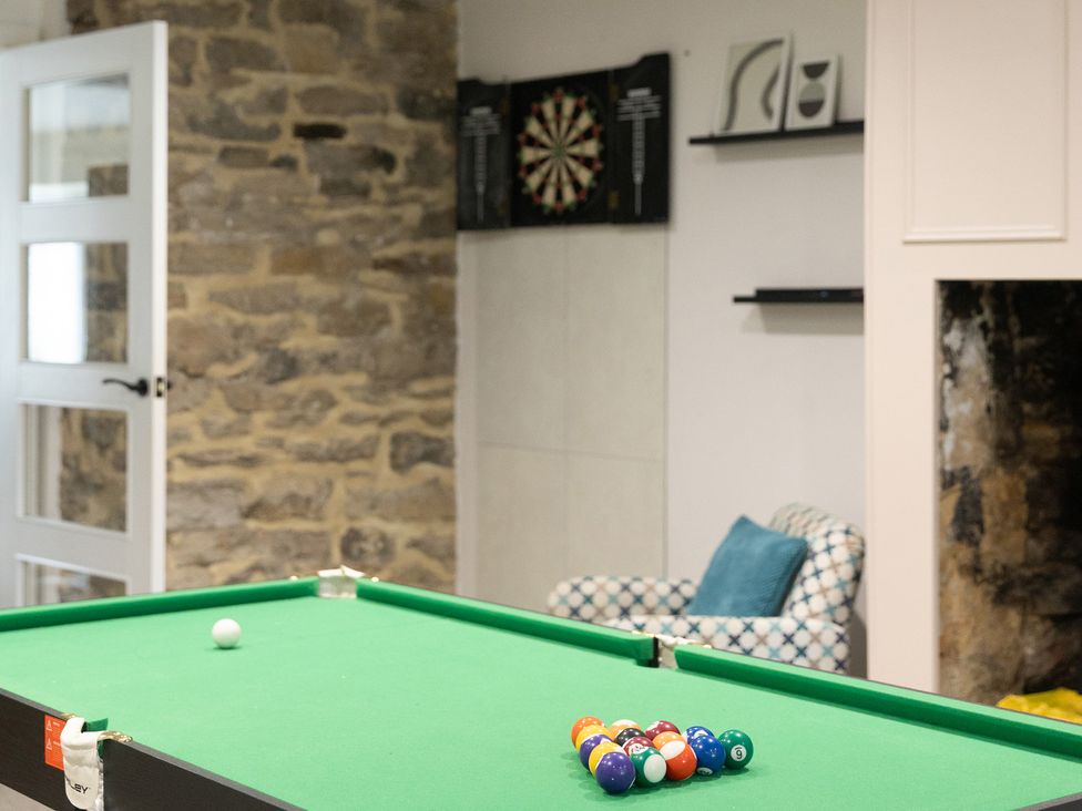 A game room with a pool table and dartboard at 6 Front Street