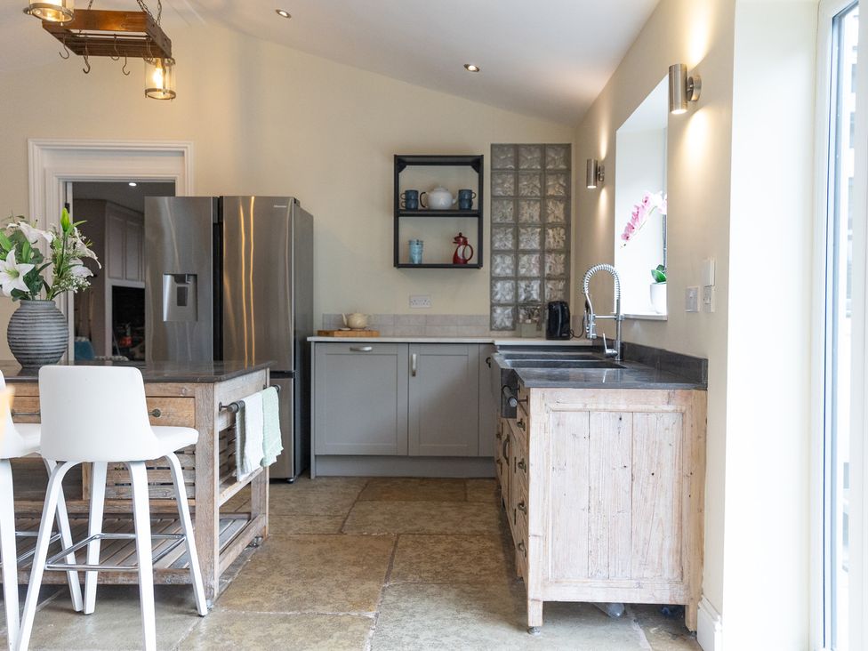 A kitchen with a refrigerator, sink, and wooden table at 6 Front Street