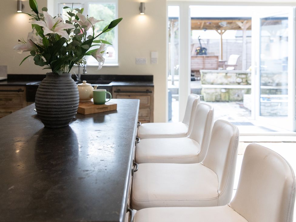 A kitchen with bar stools and a vase of flowers at 6 Front Street 