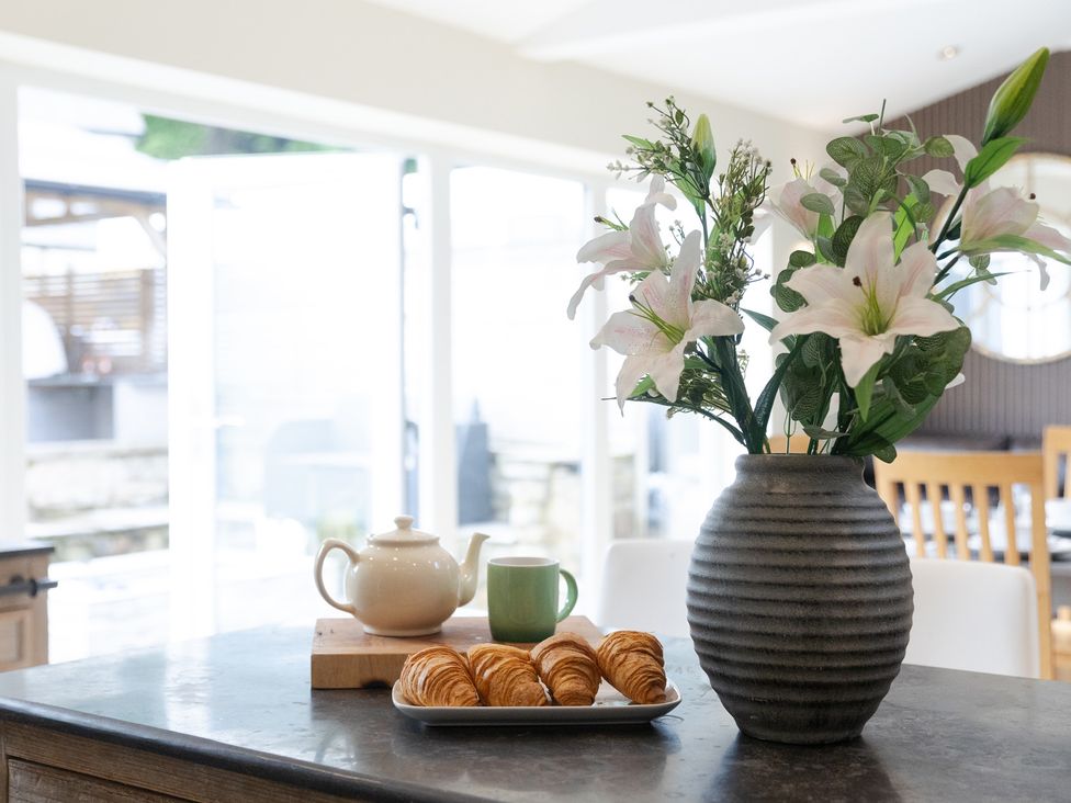 A kitchen with a vase of flowers and croissants on a table at 6 Front Street
