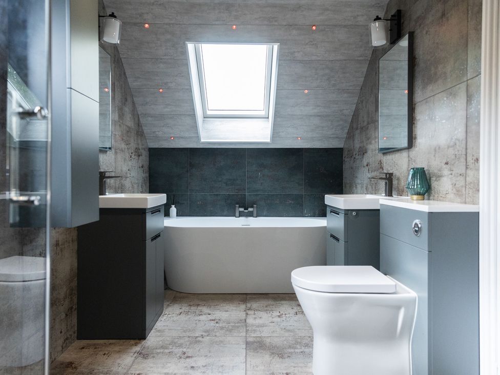 A bathroom with a bathtub, sinks and a skylight at 6 Front Street 
