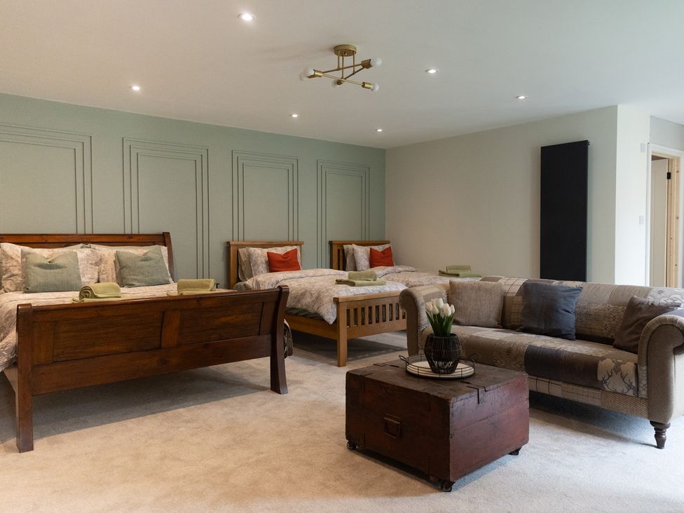 A bedroom with two beds and a sofa at 6 Front Street