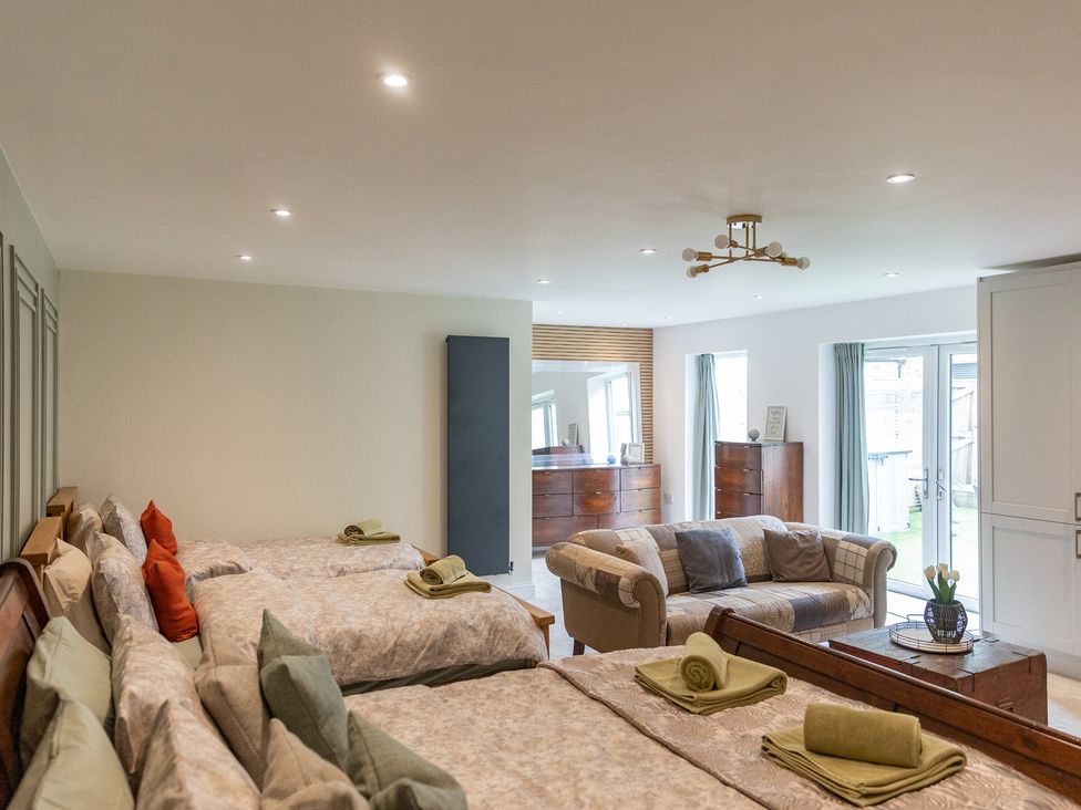 A bedroom with two beds and a sofa at 6 Front Street