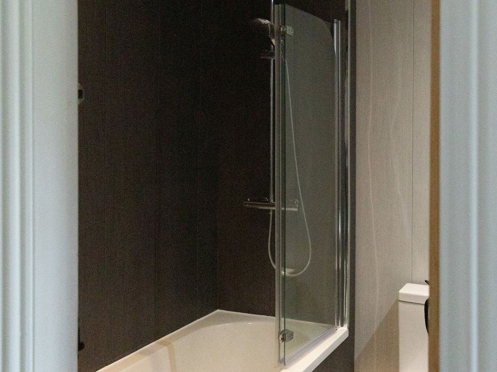 A bathtub with a shower and a toilet at 6 Front Street 