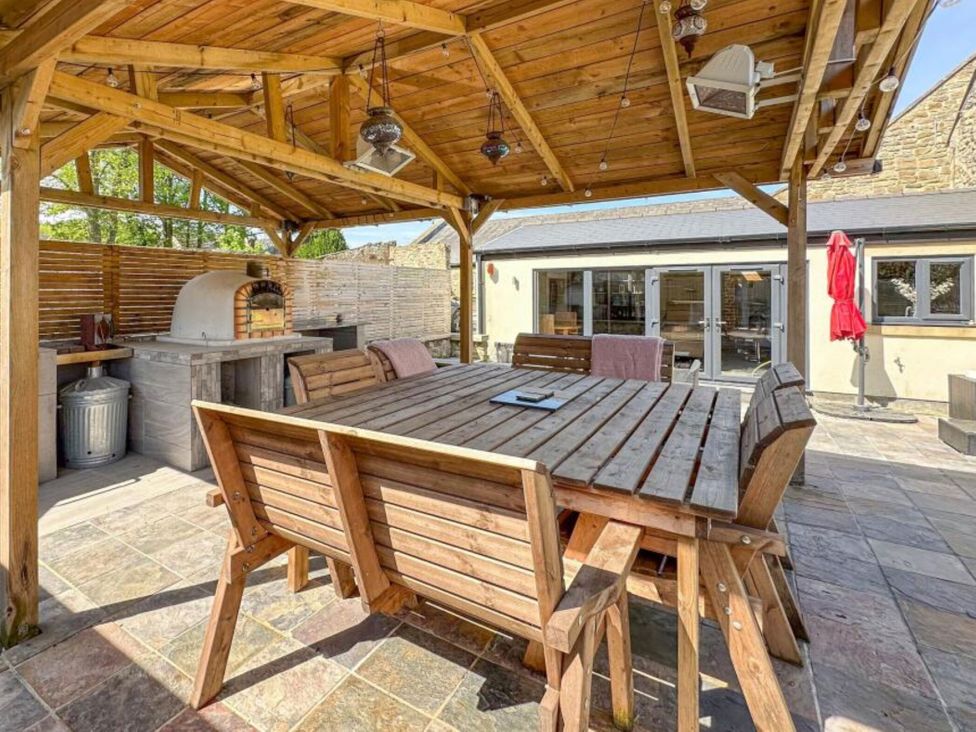 An outdoor dining area with a table and benches at The Old Sawmill in Burnopfield