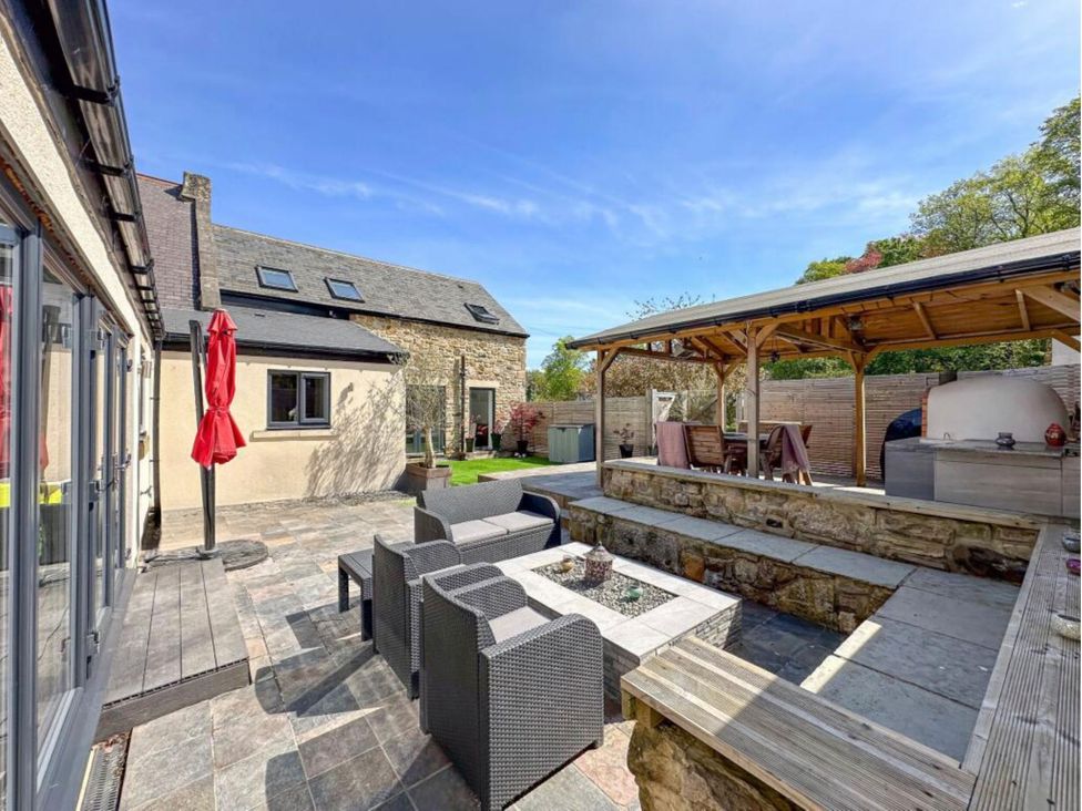 An outdoor area with seating, a fire pit, and a grill at The Old Sawmill in Burnopfield