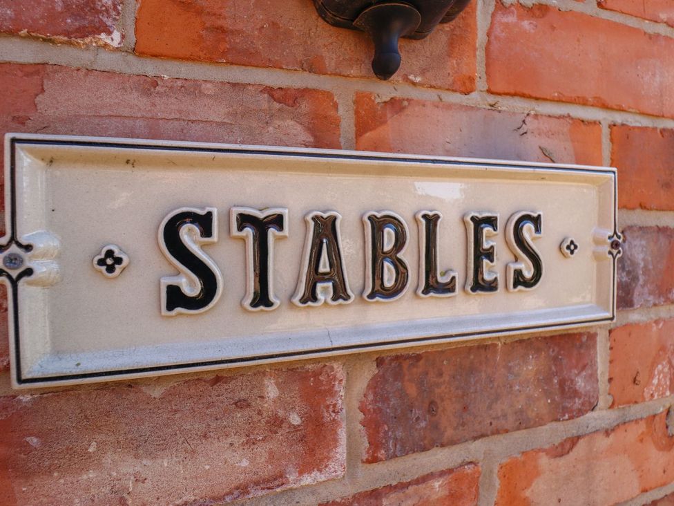 A sign with the word STABLES on a brick wall at The Stables in Louth