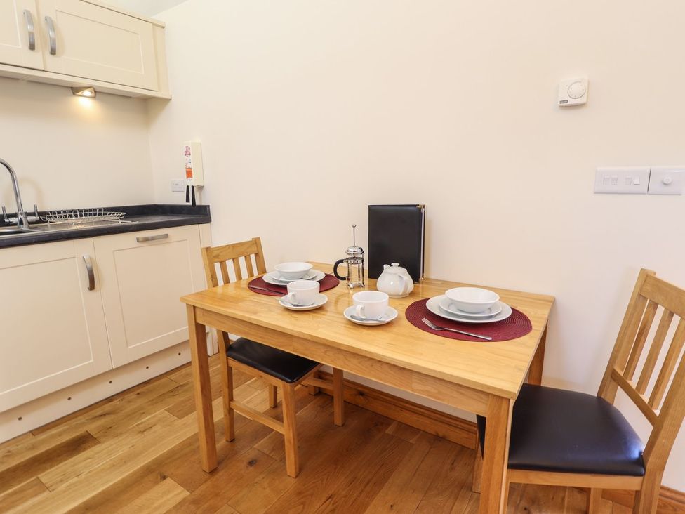 A kitchen with a table set for two at The Stables in Louth