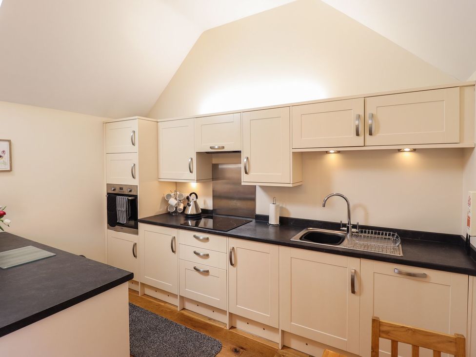 A kitchen with cabinets and appliances at The Stables in Louth