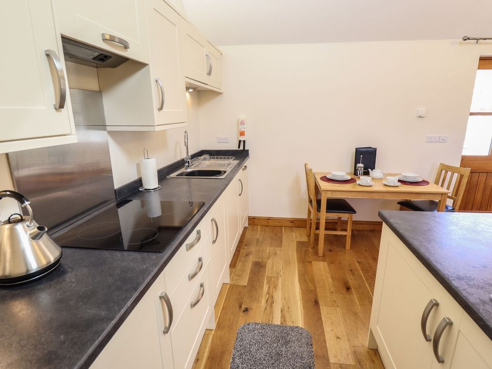 A kitchen with a table set for two at The Stables in Louth