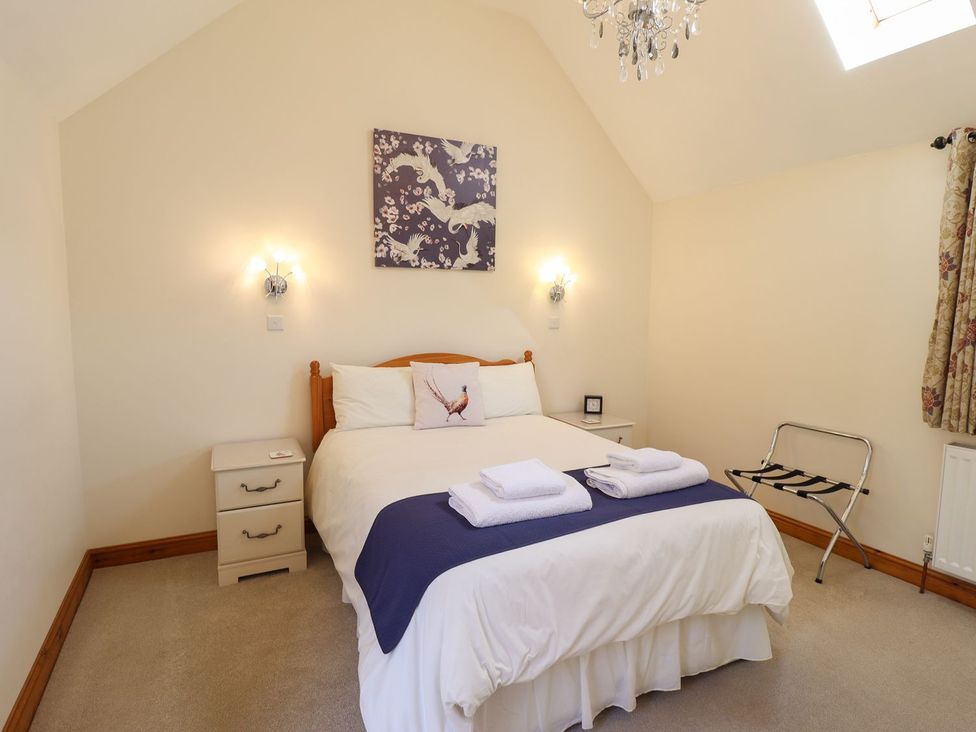 A bedroom with bed and nightstand at The Stables in Louth