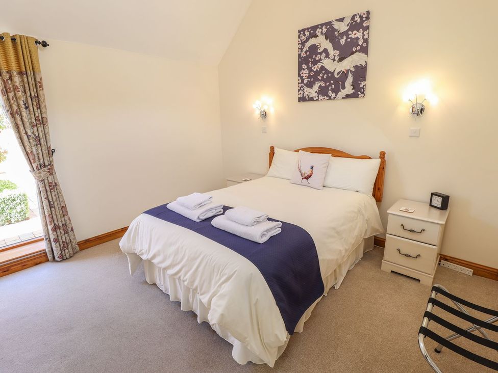 A bedroom with a bed and nightstand at The Stables in Louth