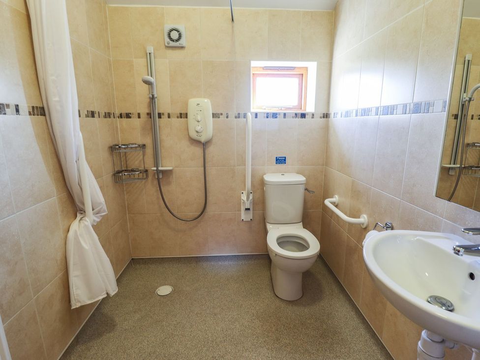 A bathroom with shower, toilet and sink at The Stables in Louth