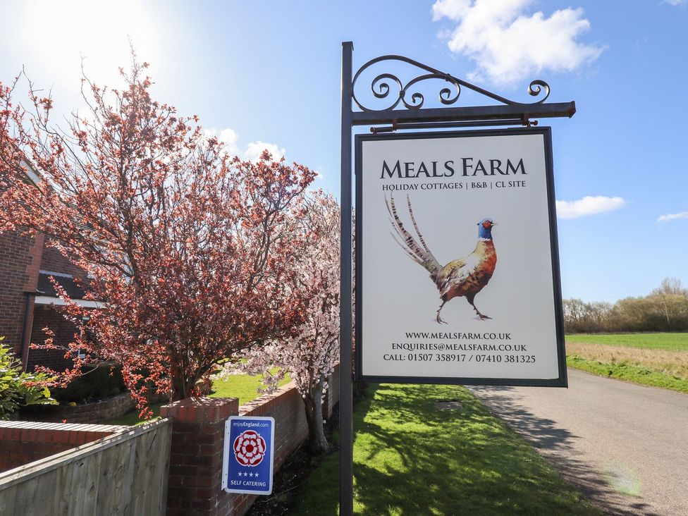 A sign for Meals Farm with trees and a field in the background at The Mill House in Louth