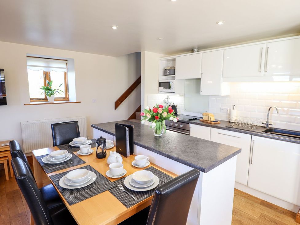 A kitchen with dining area and appliances at The Mill House in Louth