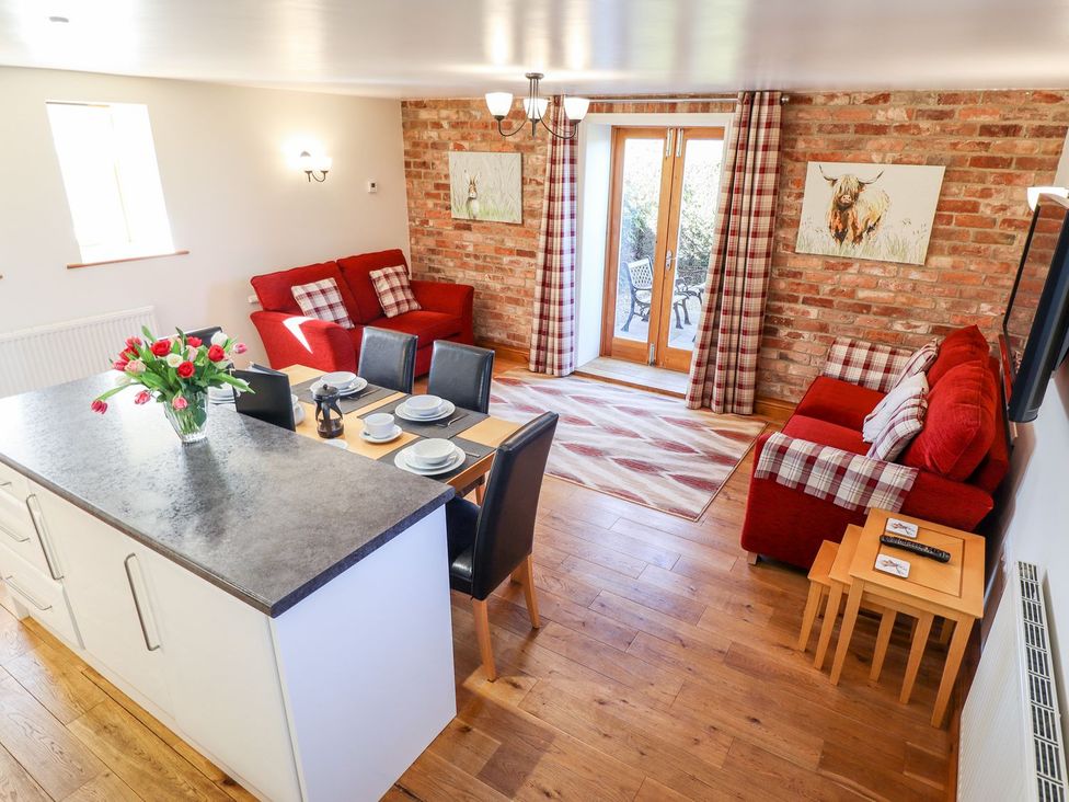 A living room with a dining area and sofa at The Mill House in Louth