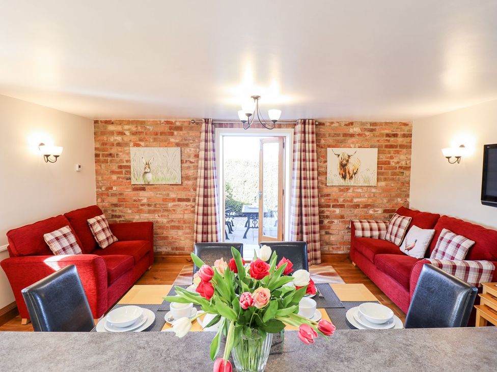 A living room with a sofa and dining table at The Mill House in Louth