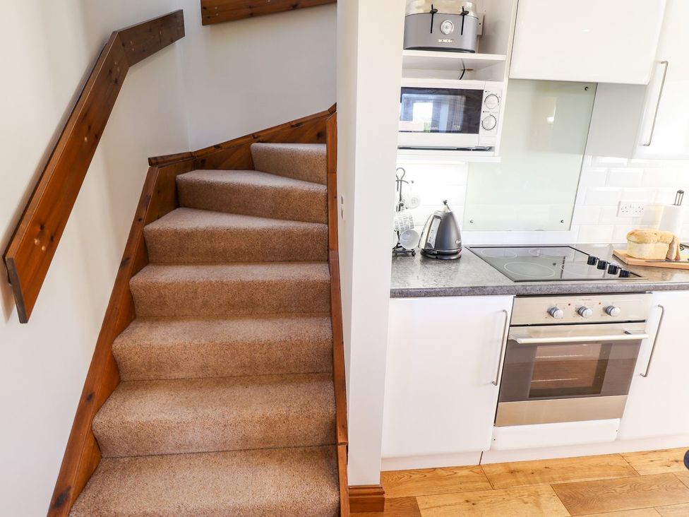 A kitchen with a staircase and appliances at The Mill House in Louth