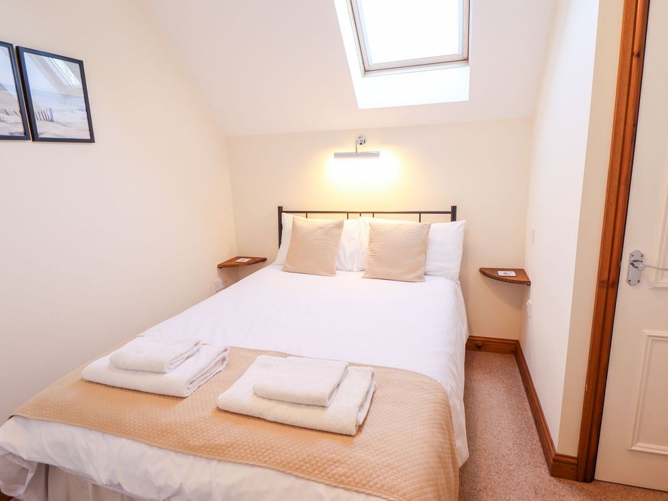 A bedroom with a bed and wall art at The Mill House in Louth
