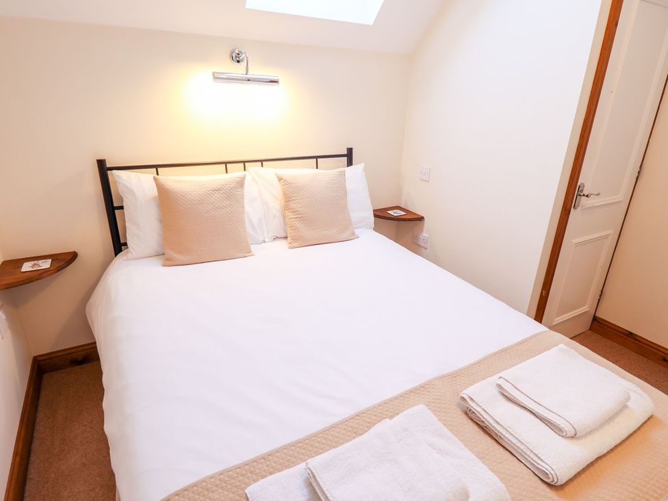 A bedroom with a bed and bedside table at The Mill House in Louth