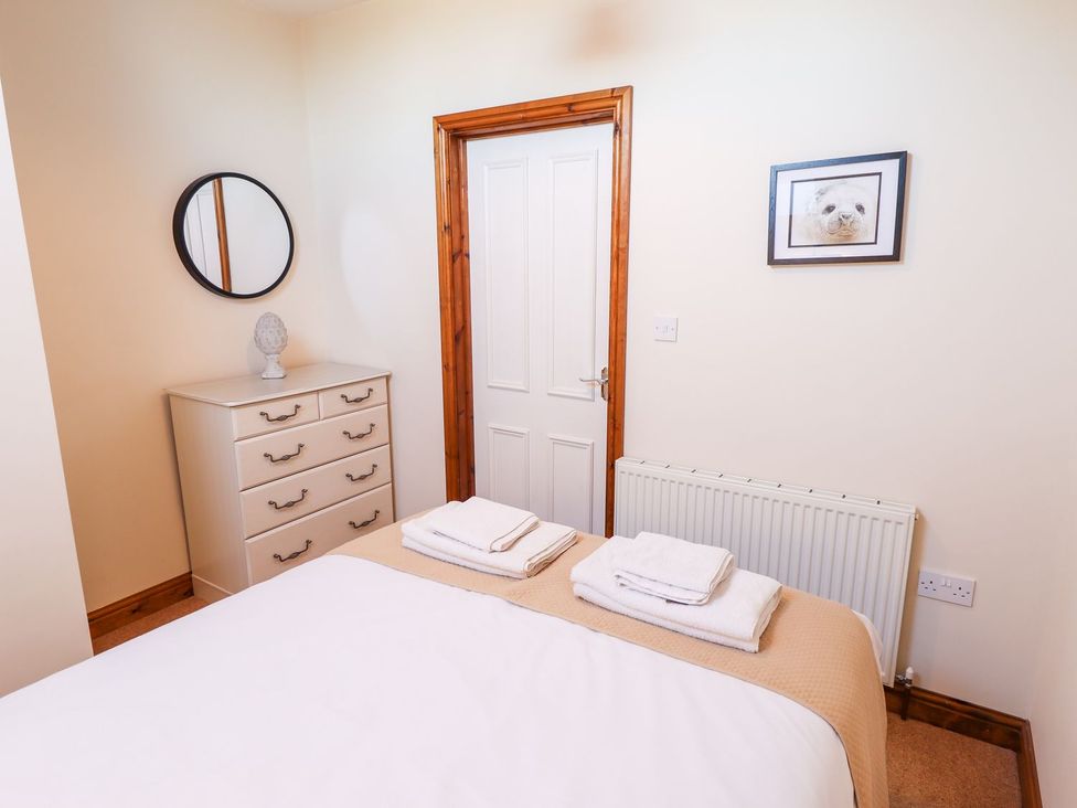 A bedroom with a bed and dresser at The Mill House in Louth