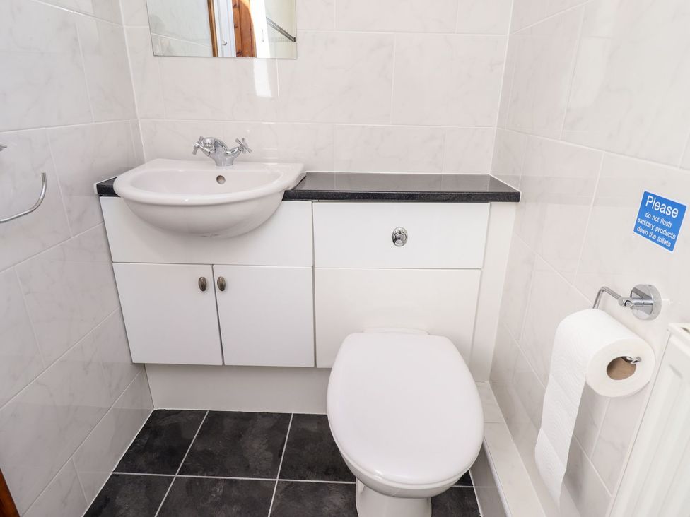 A bathroom featuring a sink, toilet, and cabinet at The Mill House in Louth