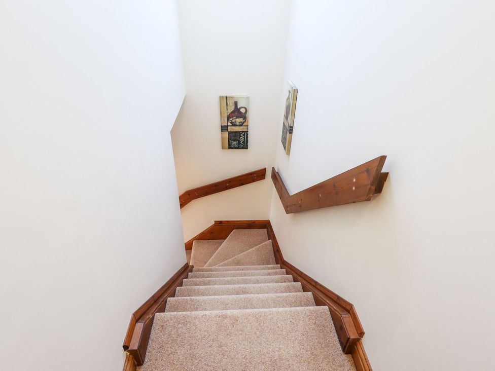 A staircase with a railing and wall art at The Mill House in Louth