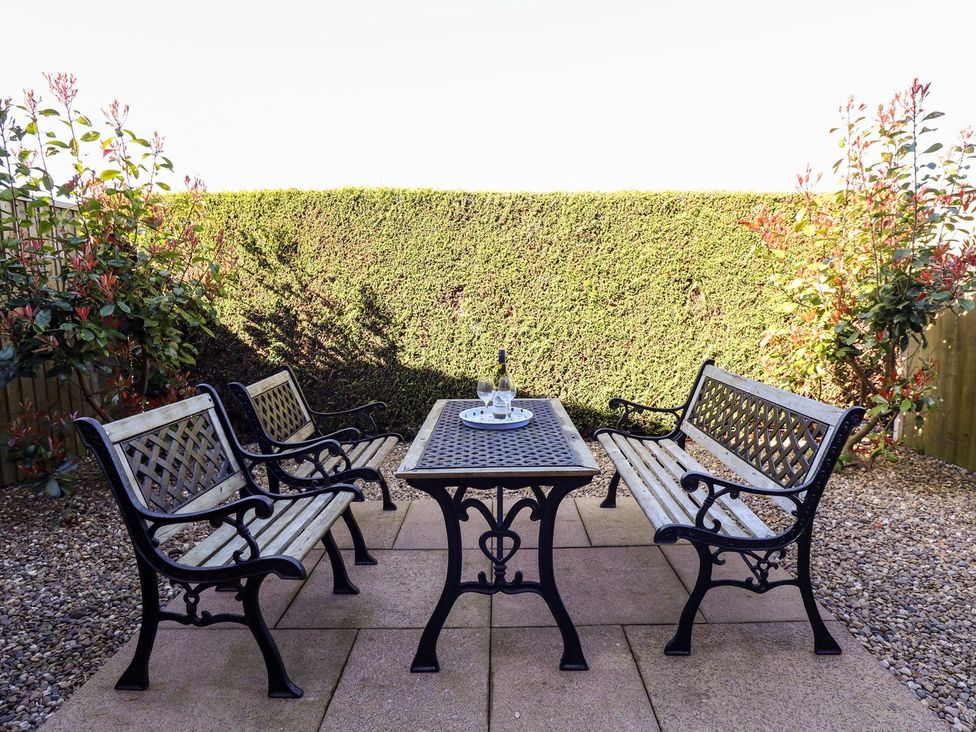 A garden with benches and a table at The Mill House in Louth
