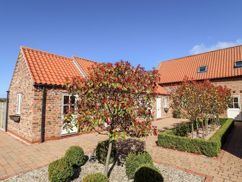 An outdoor area with brick buildings and trees at The Mill House in Louth