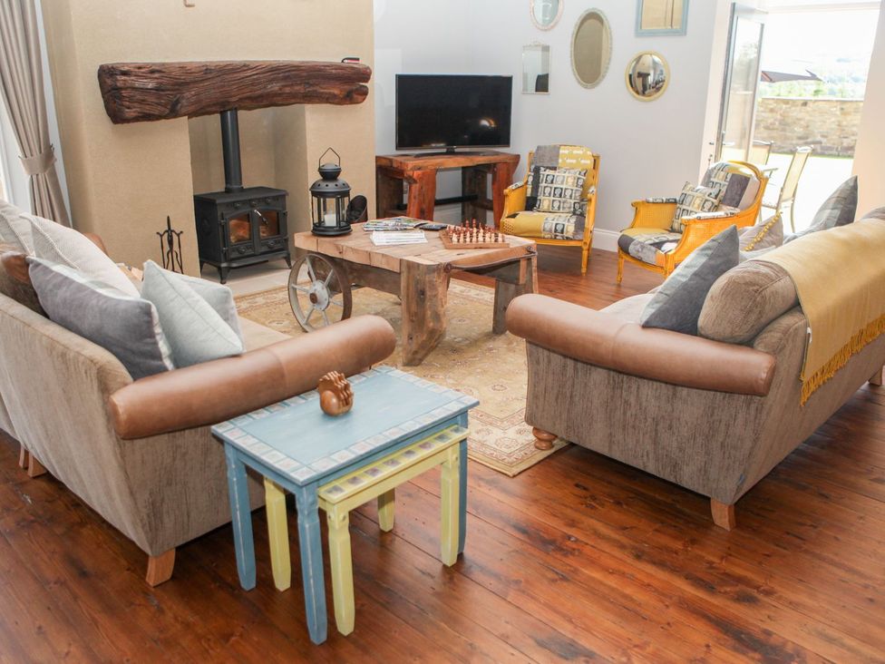 A living room with sofas, coffee table, TV and armchairs at The Granary in Durham