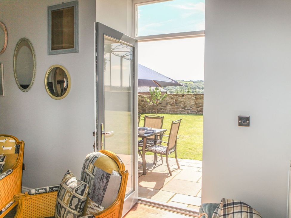 A living room with a door leading to a patio area at The Granary in Durham