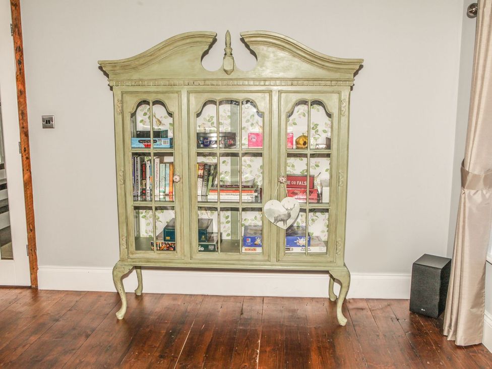 A cabinet with books and decorative items at The Granary in Durham