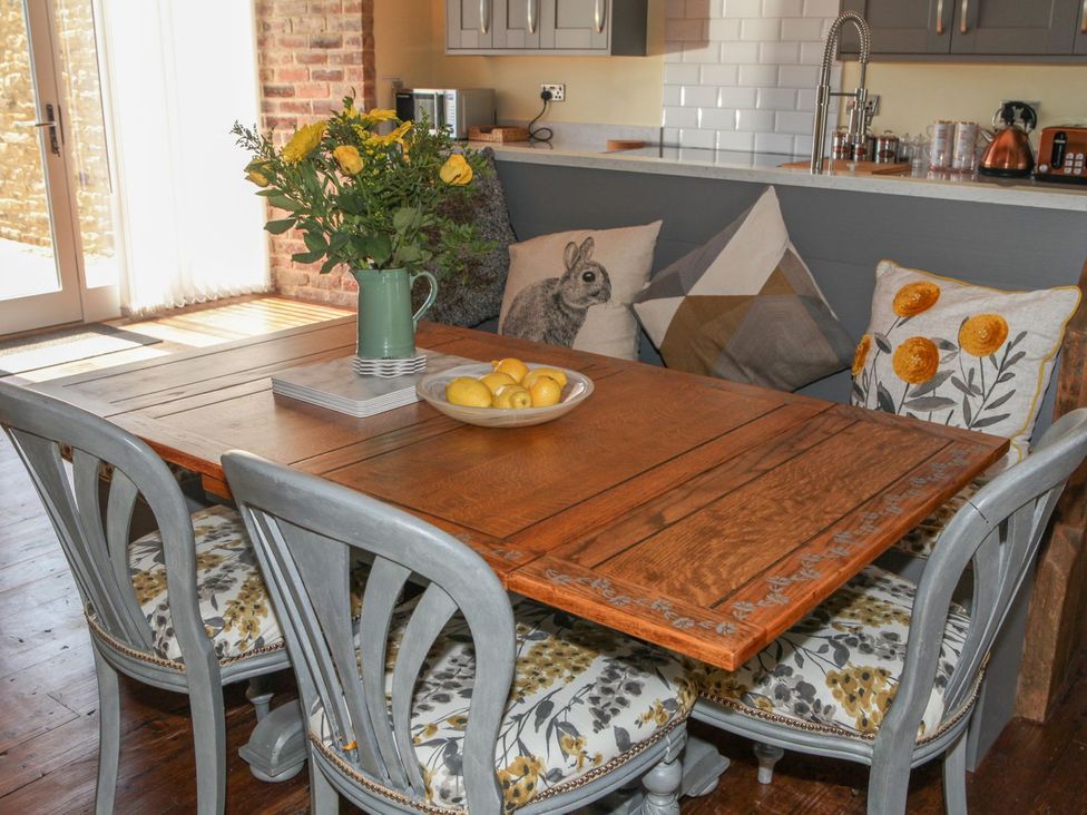 A dining room with a wooden table and chairs at The Granary in Durham