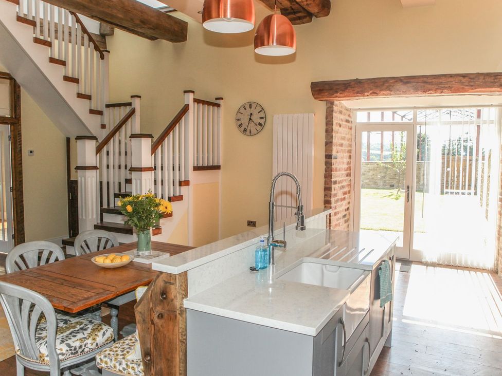 A kitchen with a dining table and chairs at The Granary in Durham
